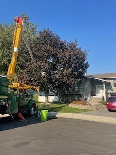 Truck Parked In Front Of A House With A Tree On Top - Benton City, WA - Aria Tree Service