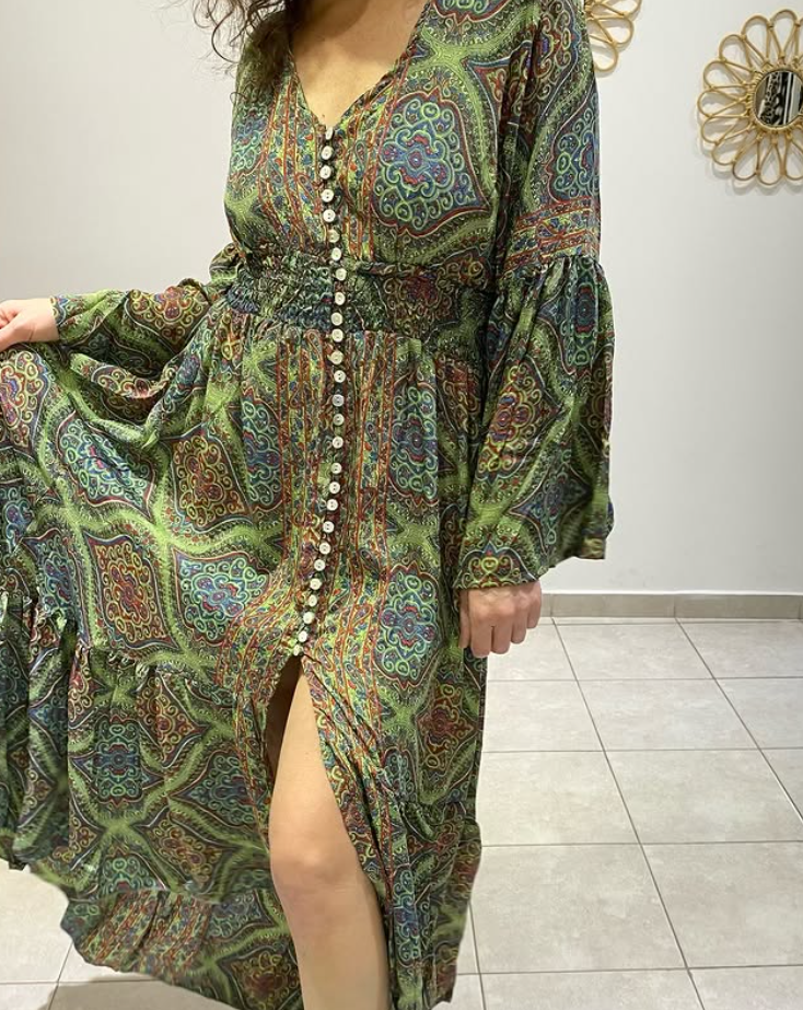Mujer con vestido paisley verde con botones en la parte delantera, mangas largas y abertura en la pierna.