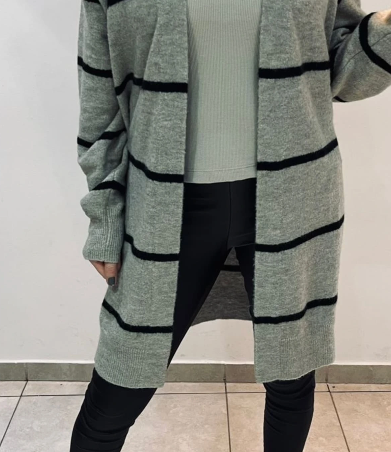 Mujer con cárdigan gris con rayas negras, leggings negros y top verde claro.
