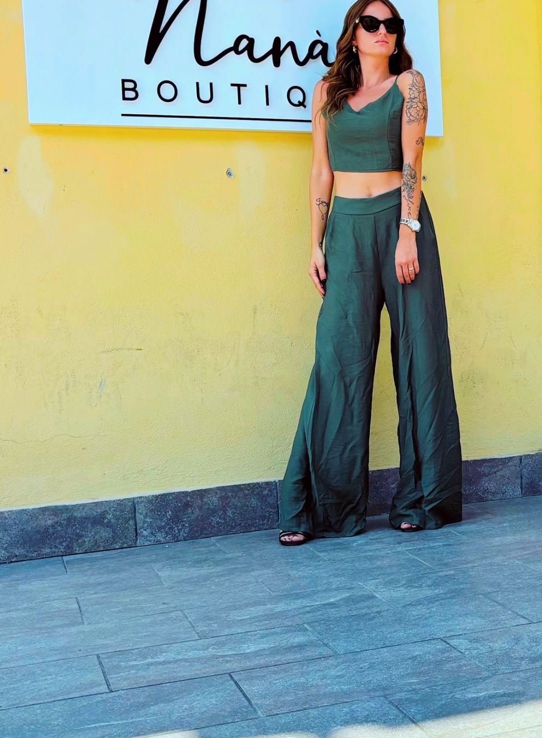 Una donna è in piedi davanti al cartello di una boutique di nana