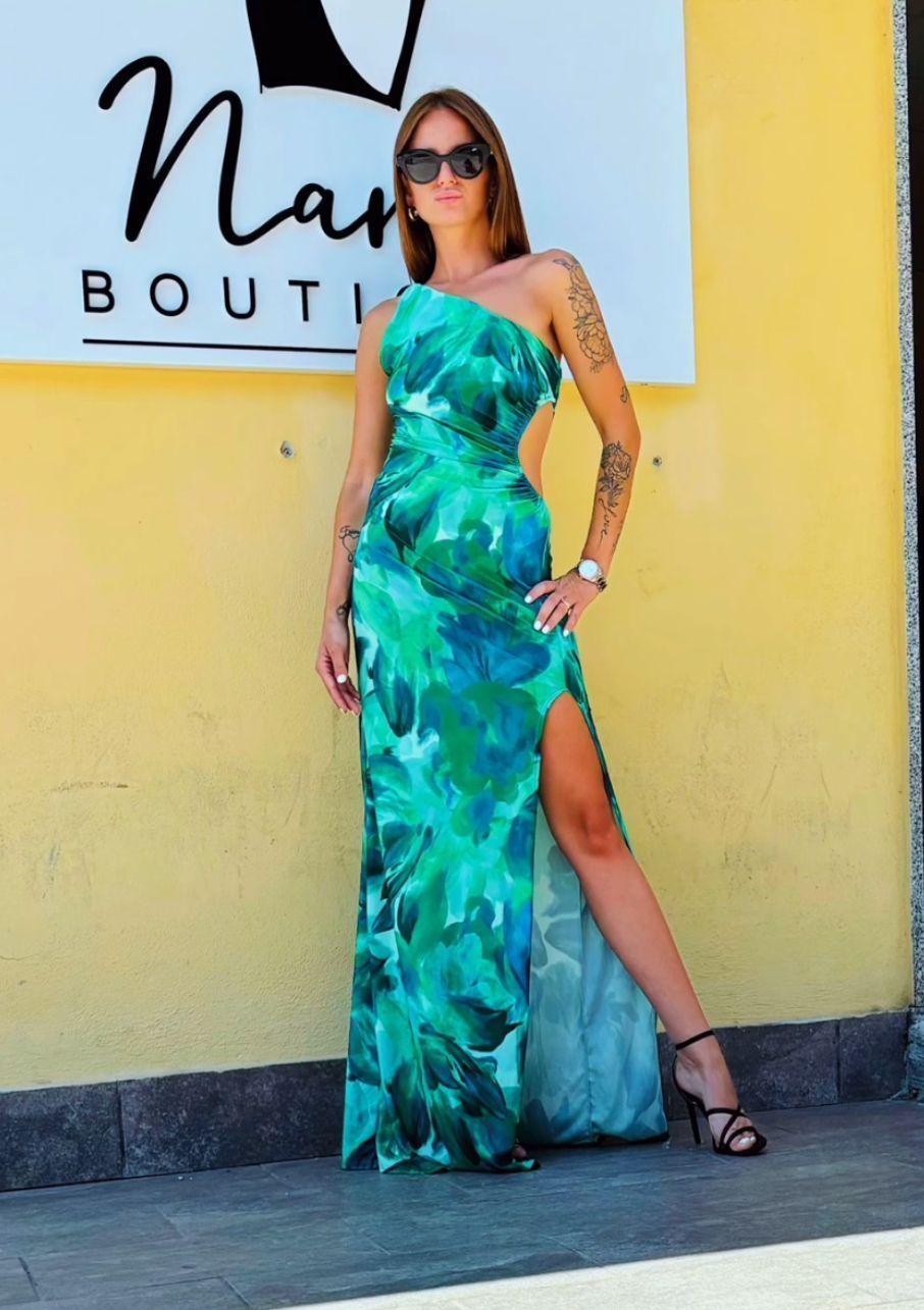 Una donna con un vestito verde è in piedi davanti a un cartello che dice boutique