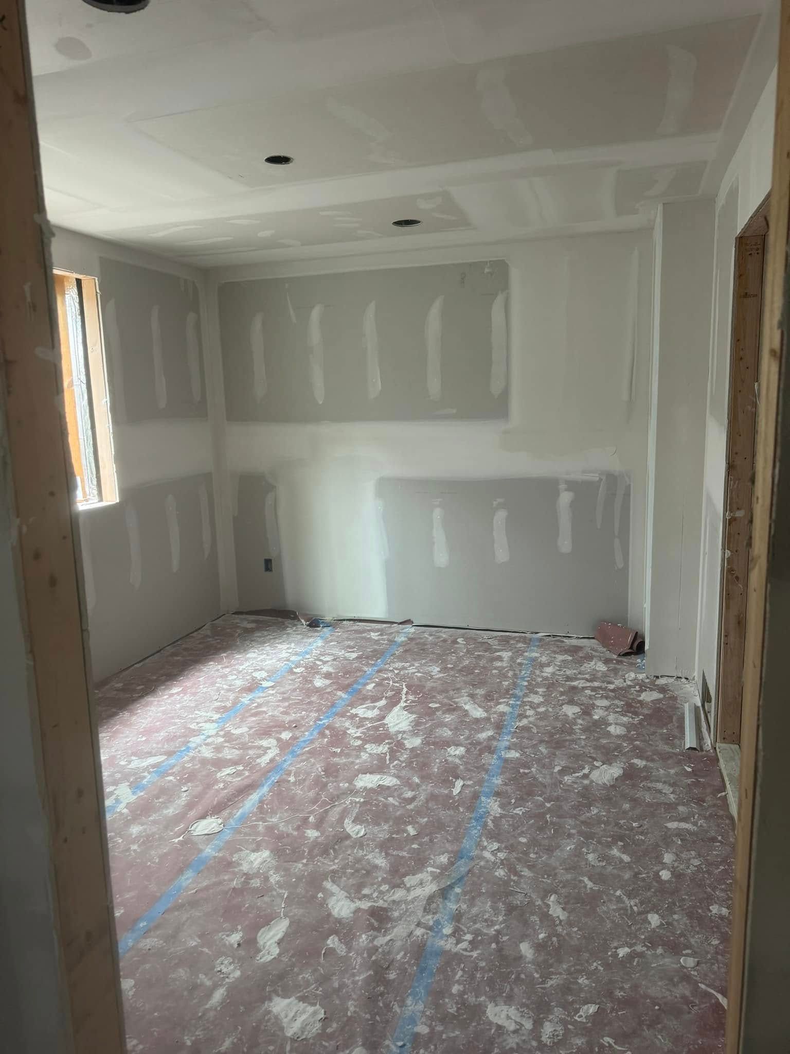 Room under construction with drywall, open doorway, and debris on floor.