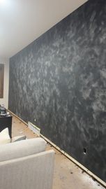 Dark gray textured accent wall, with a sofa in the foreground.