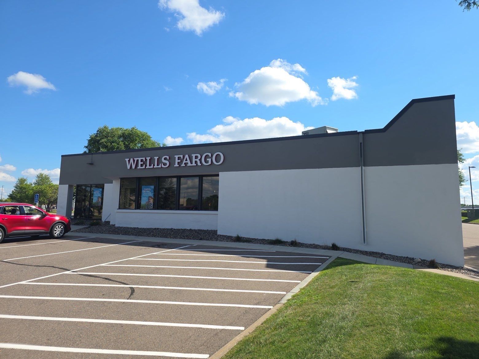 Wells Fargo bank building with a red car in front on a sunny day.