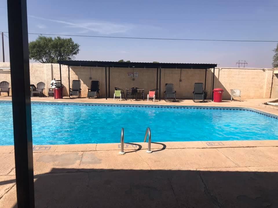 A large swimming pool with chairs and tables around it