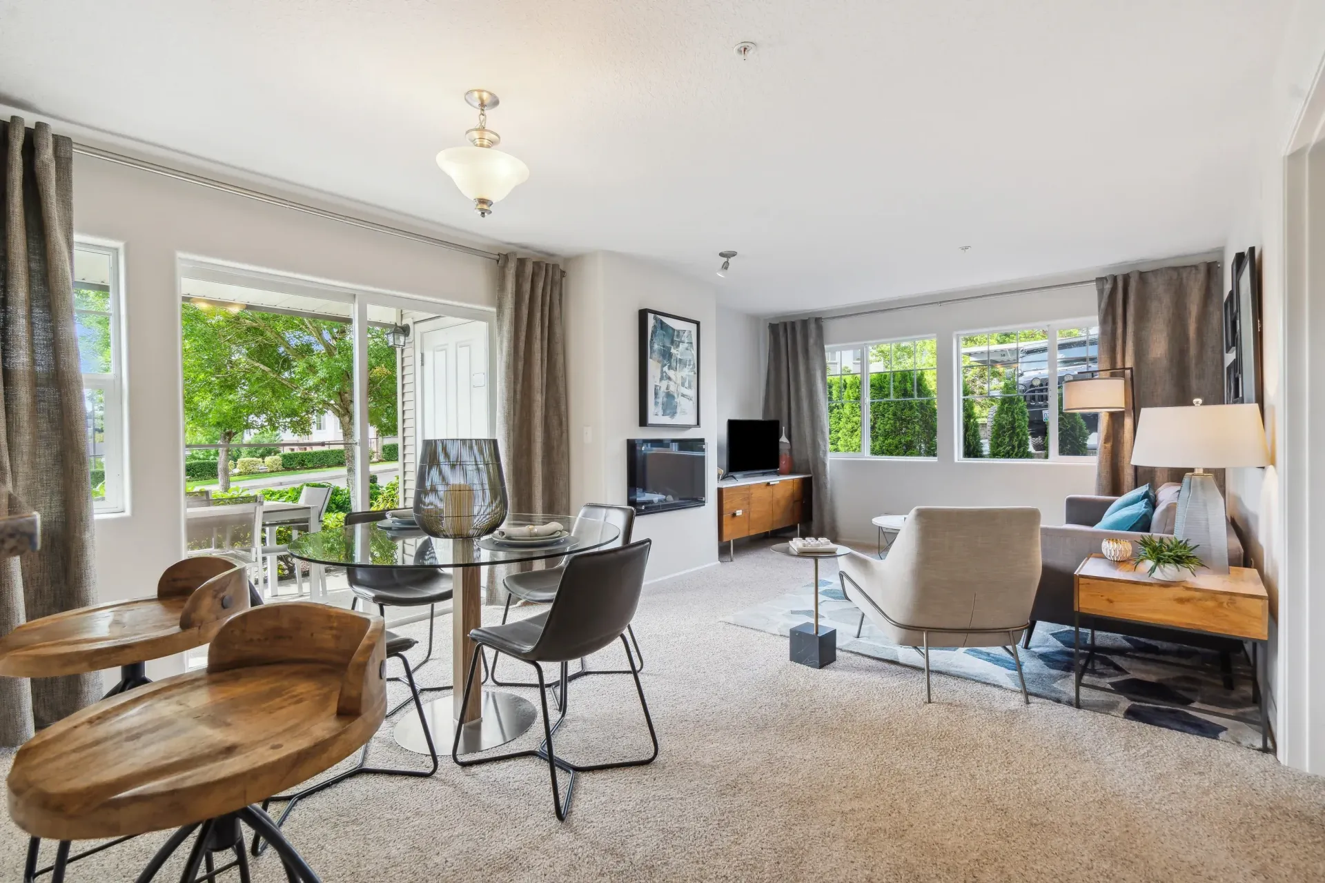 Living room with large windows, dining table, and modern furniture.