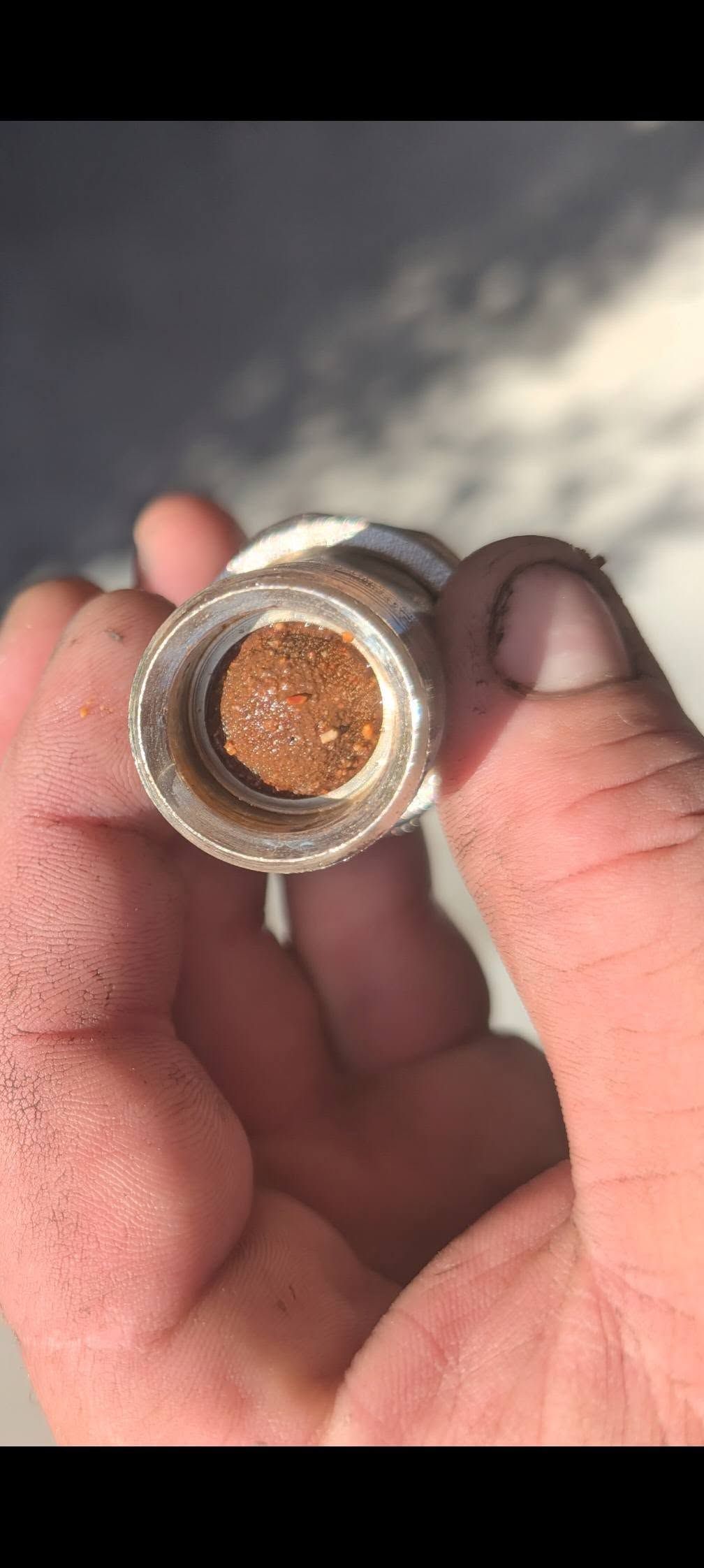 A Copper Pipe With a Coupling Fitting Lies in a Shallow