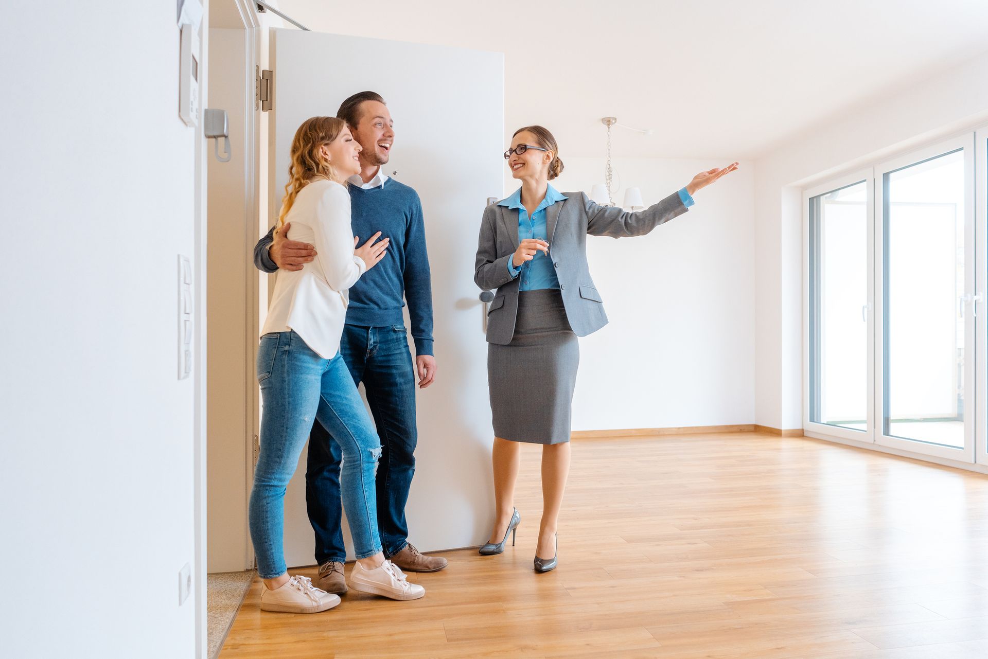 A real estate agent is showing a couple a new apartment.