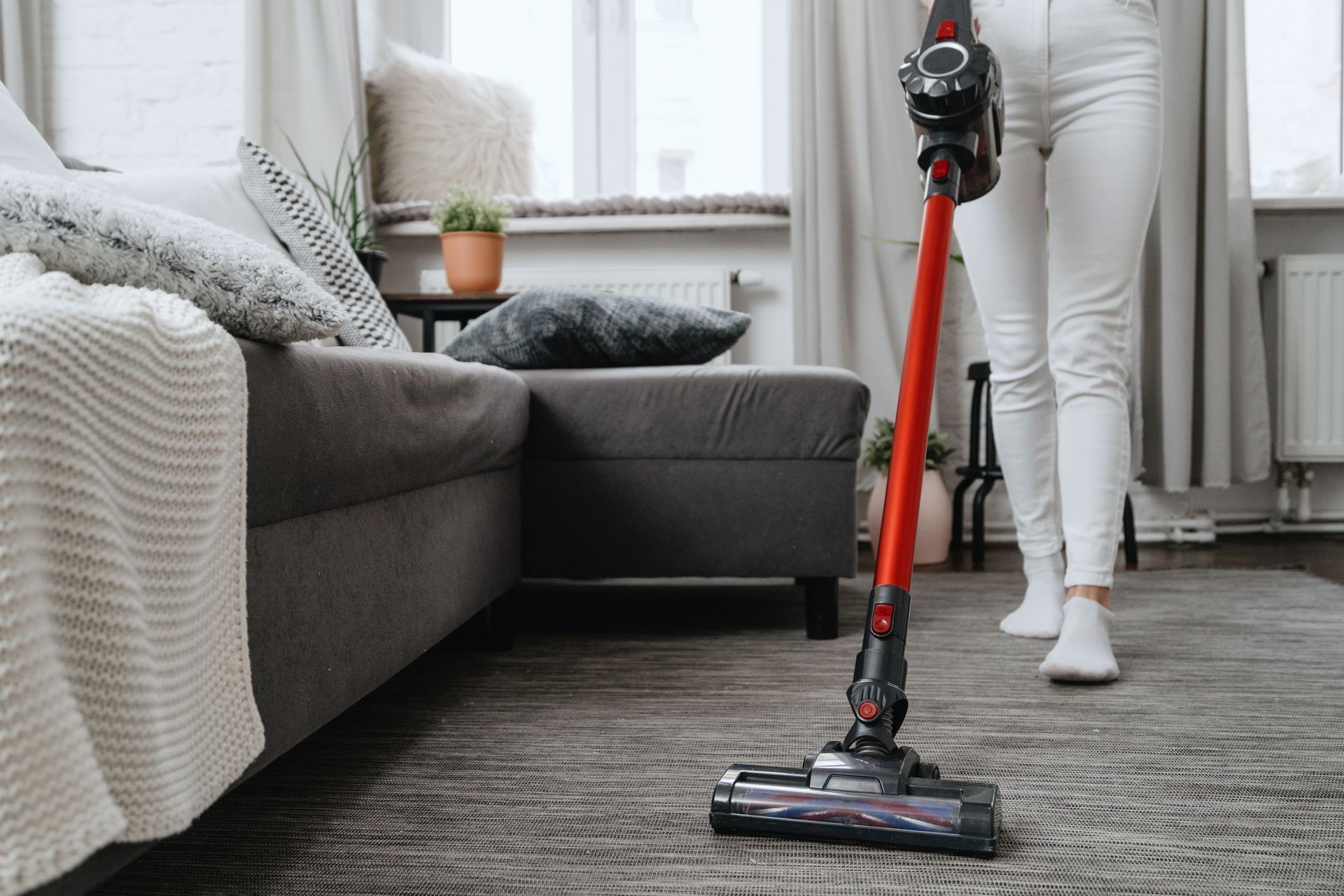 Woman vacuuming a rug 
