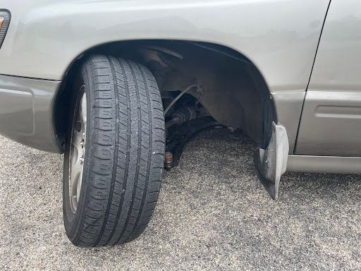 A close up of a car tire on a gravel road.