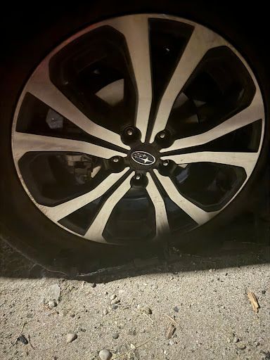 A close up of a car wheel on the ground.