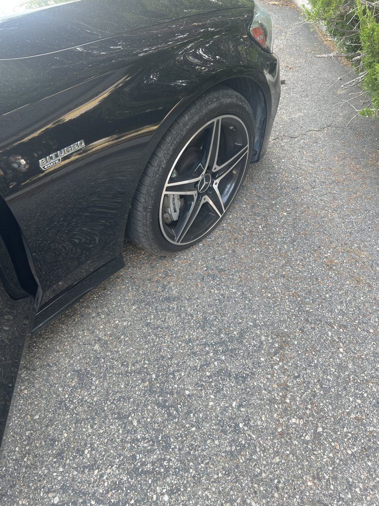 A black car is parked on the side of the road.