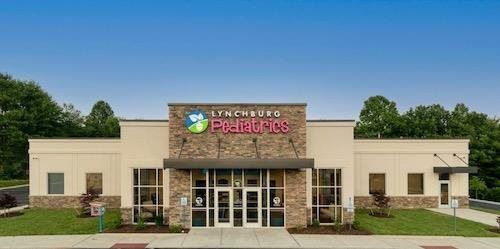 A single-story commercial building with stone accents and a sign reading 