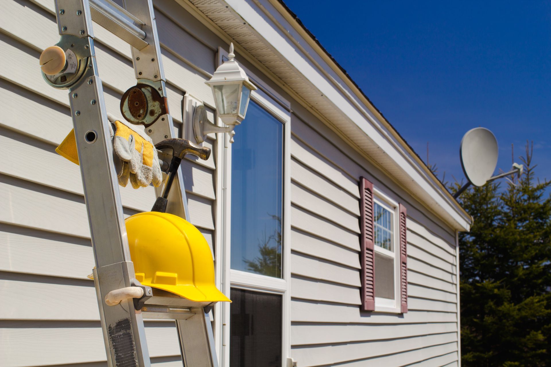Hard hat and tools ready for residential siding services and exterior home improvement repairs.