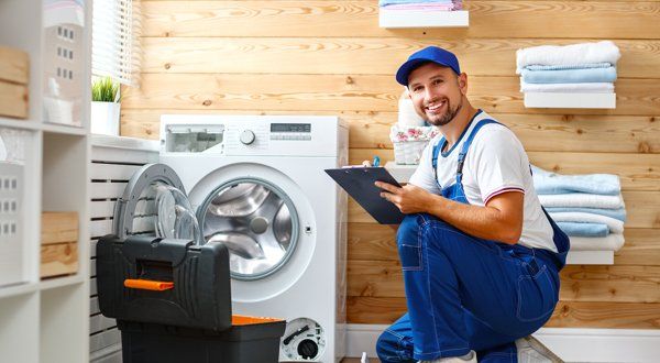 Man Plumber Repairs Washing Machine in Laundry — Voorhees, NJ — Appliance Werks