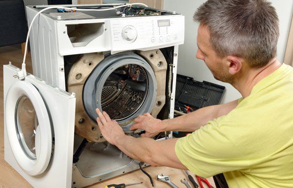 Service Man Fixing a Washing Machine — Voorhees, NJ — Appliance Werks