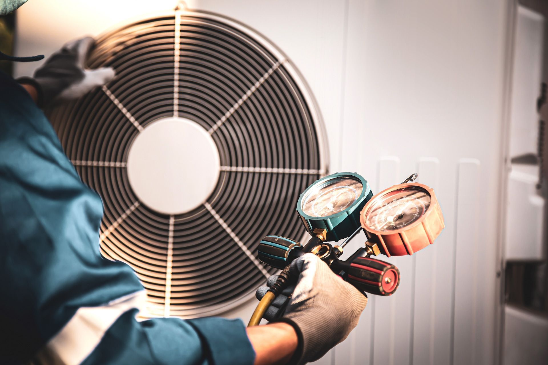 A man is working on an air conditioner with a vacuum gauge.