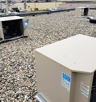 A box with the word bohn on it is sitting on a rocky roof.