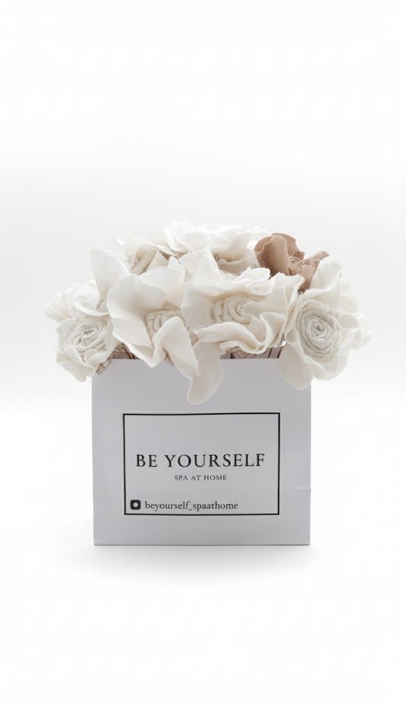 Caja cuadrada blanca con flores blancas y tostadas; texto