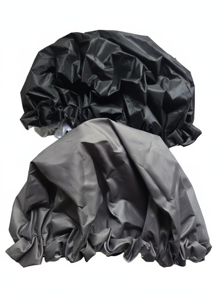 Dos gorros de ducha, uno negro y otro gris, con bordes con volantes.