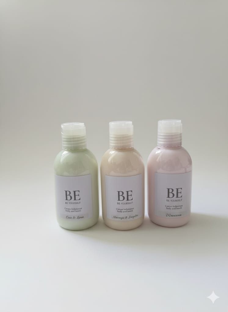Tres pequeñas botellas de color pastel con etiquetas y tapones blancos, sobre fondo blanco.