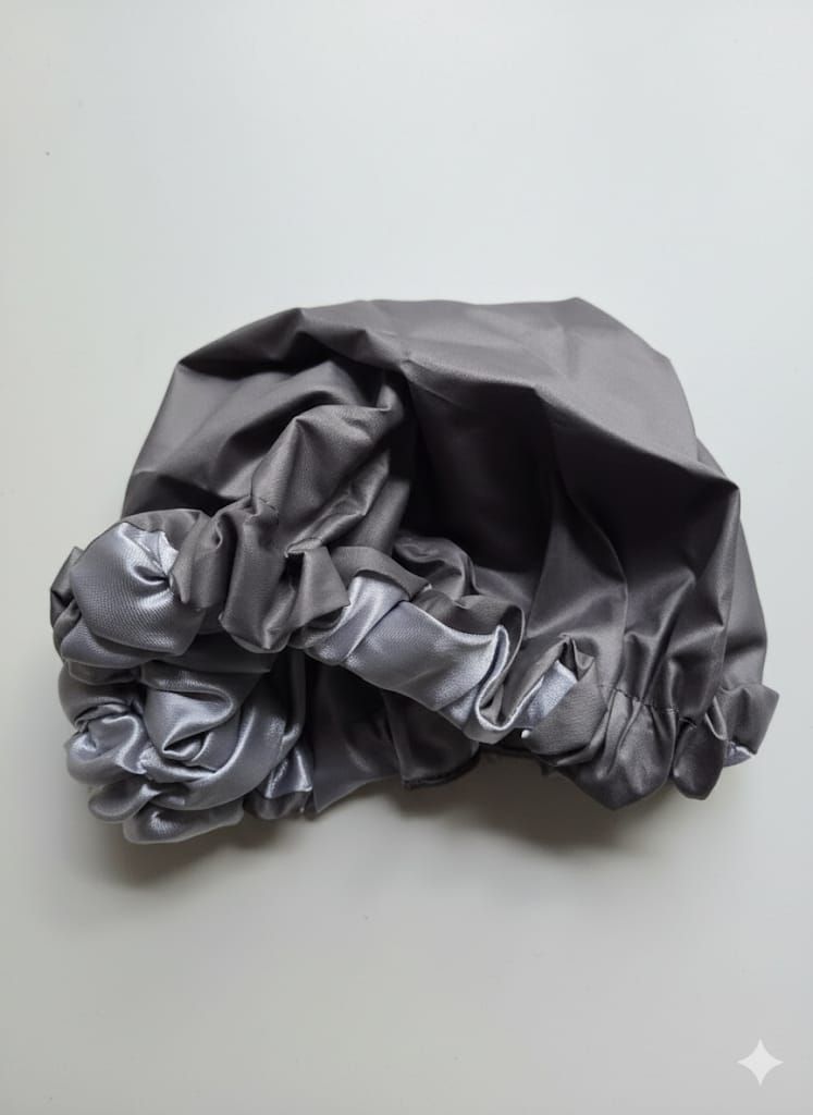 Dos gorros de ducha, uno negro y otro gris, con bordes con volantes.