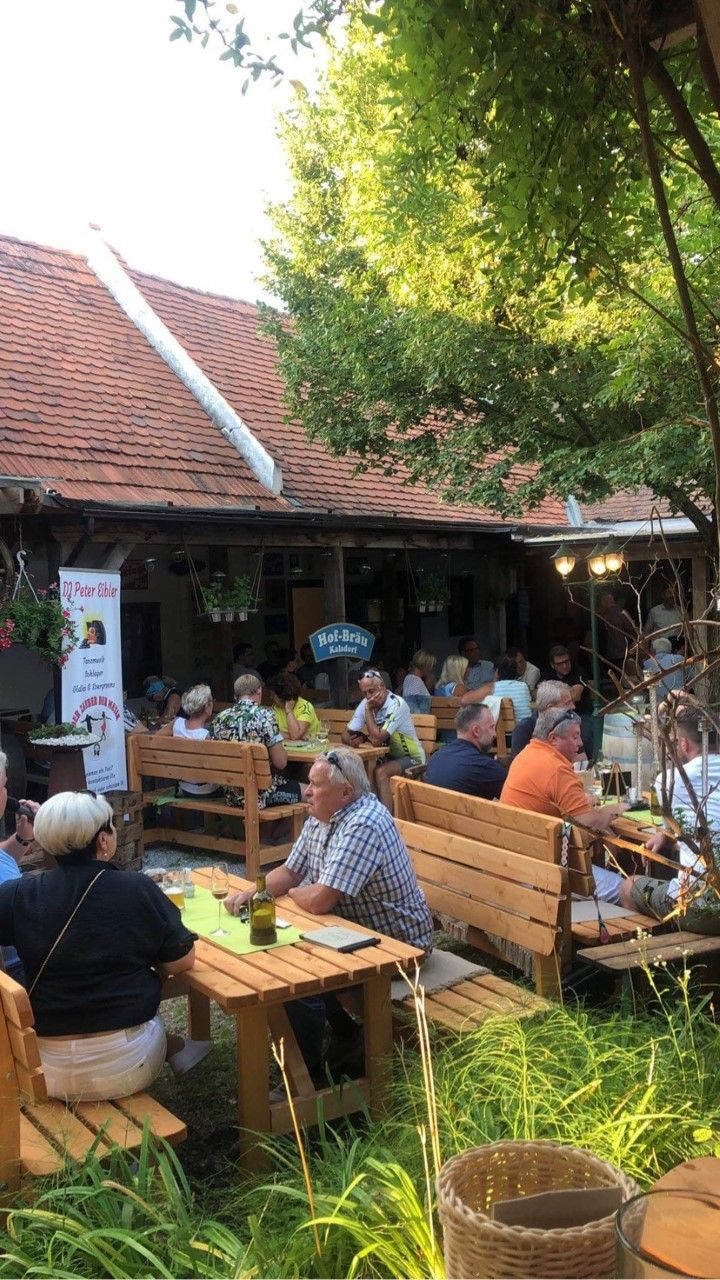 Gäste sitzen im Außenbereich von Heuriger Kager´s Auszeit