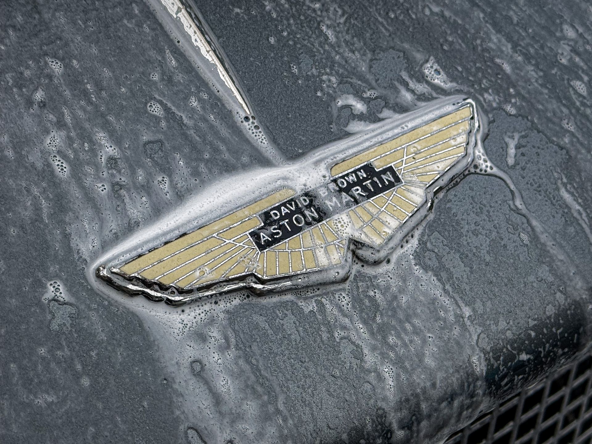 Een close-up van een Aston Martin-embleem op een auto