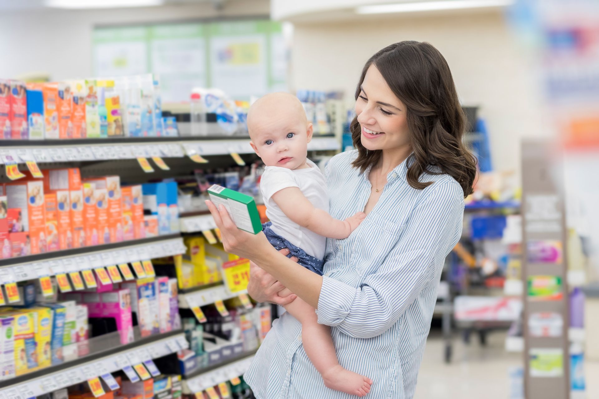 Una donna tiene in braccio un bambino in un supermercato.