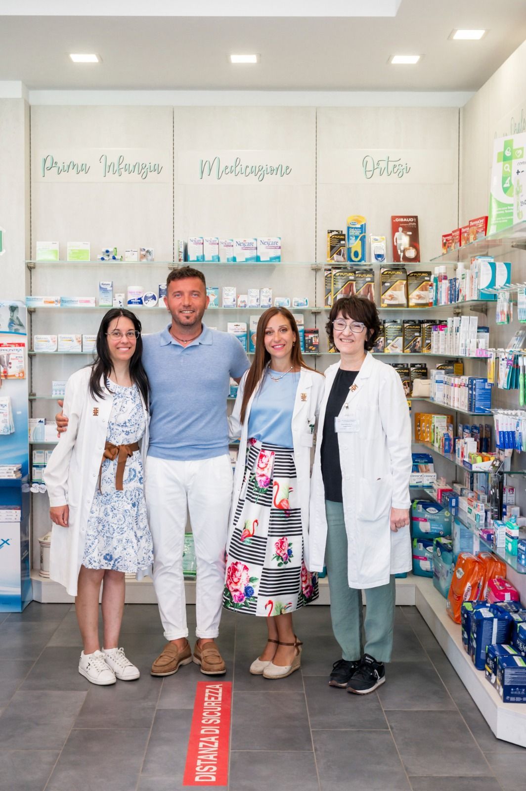 Un gruppo di persone posa per una foto in una farmacia.