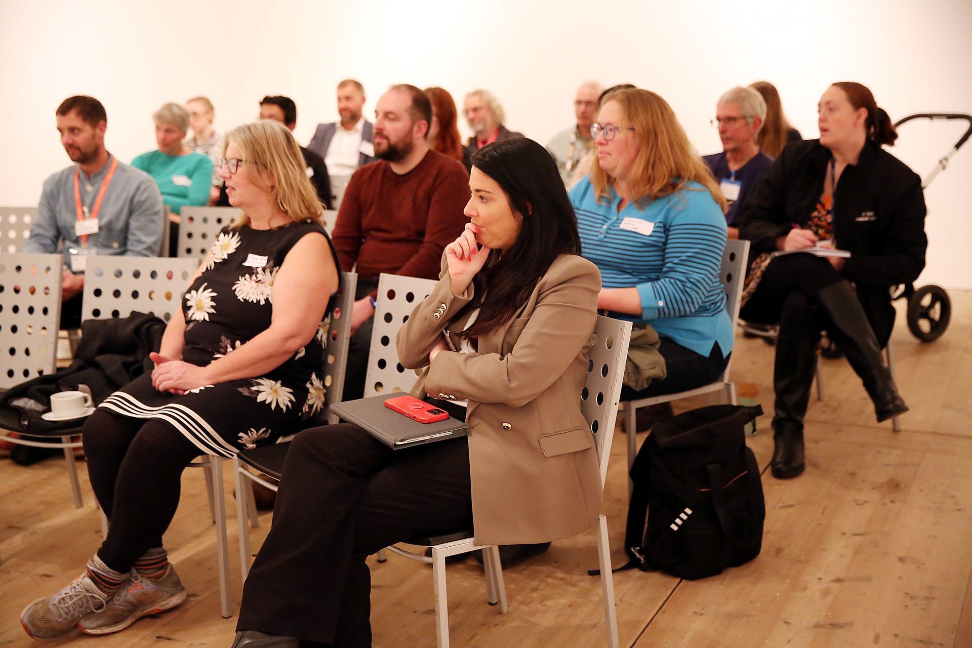 A group of people are sitting in chairs watching a presentation.