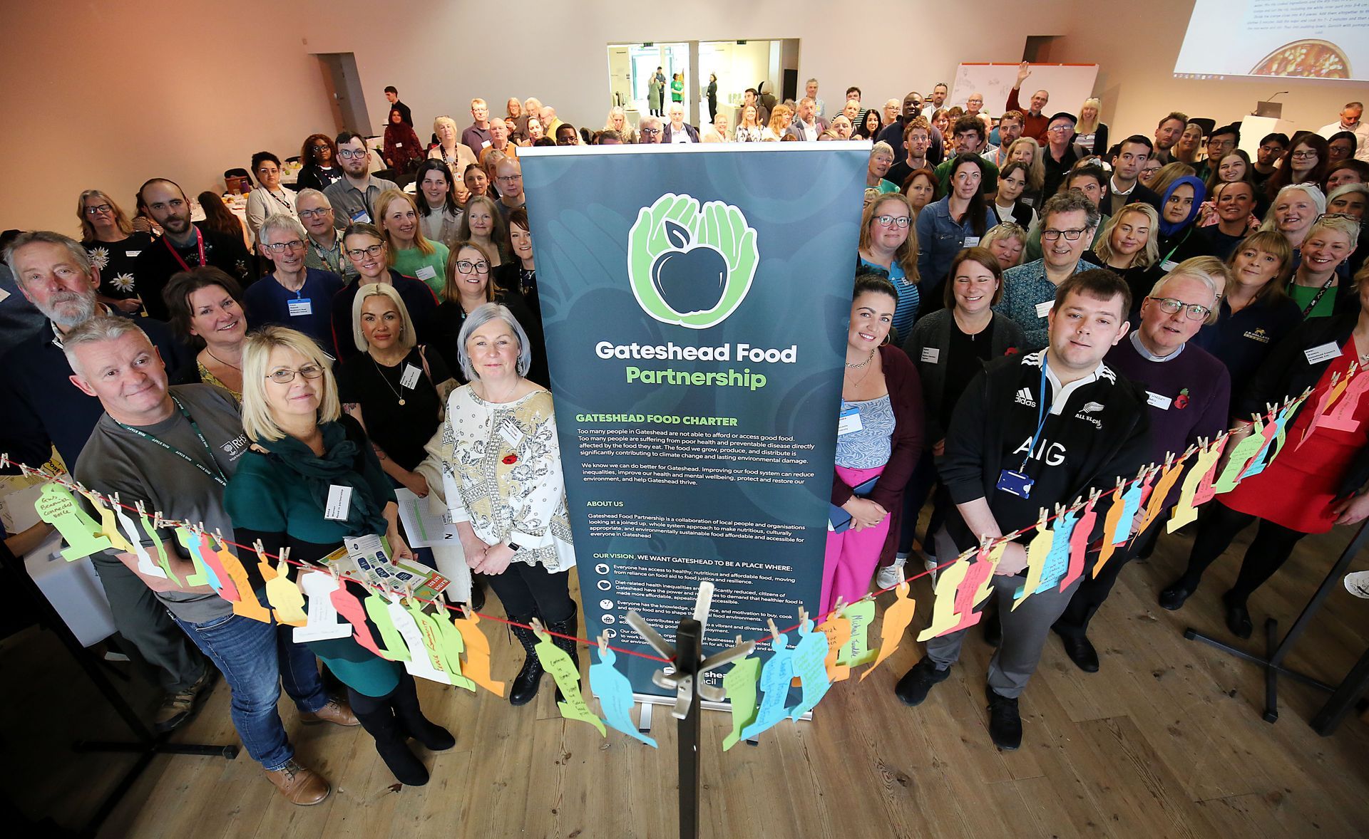 A large group of people standing in front of a sign that says jada bread food