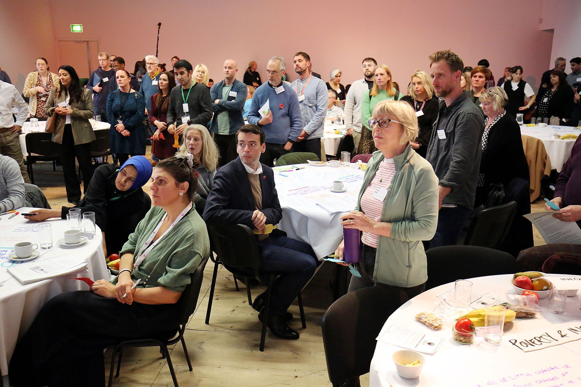 A large group of people are sitting at tables in a room.