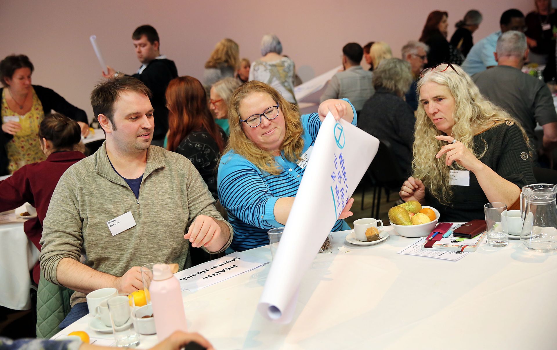 A group of people are sitting at a table looking at a piece of paper.