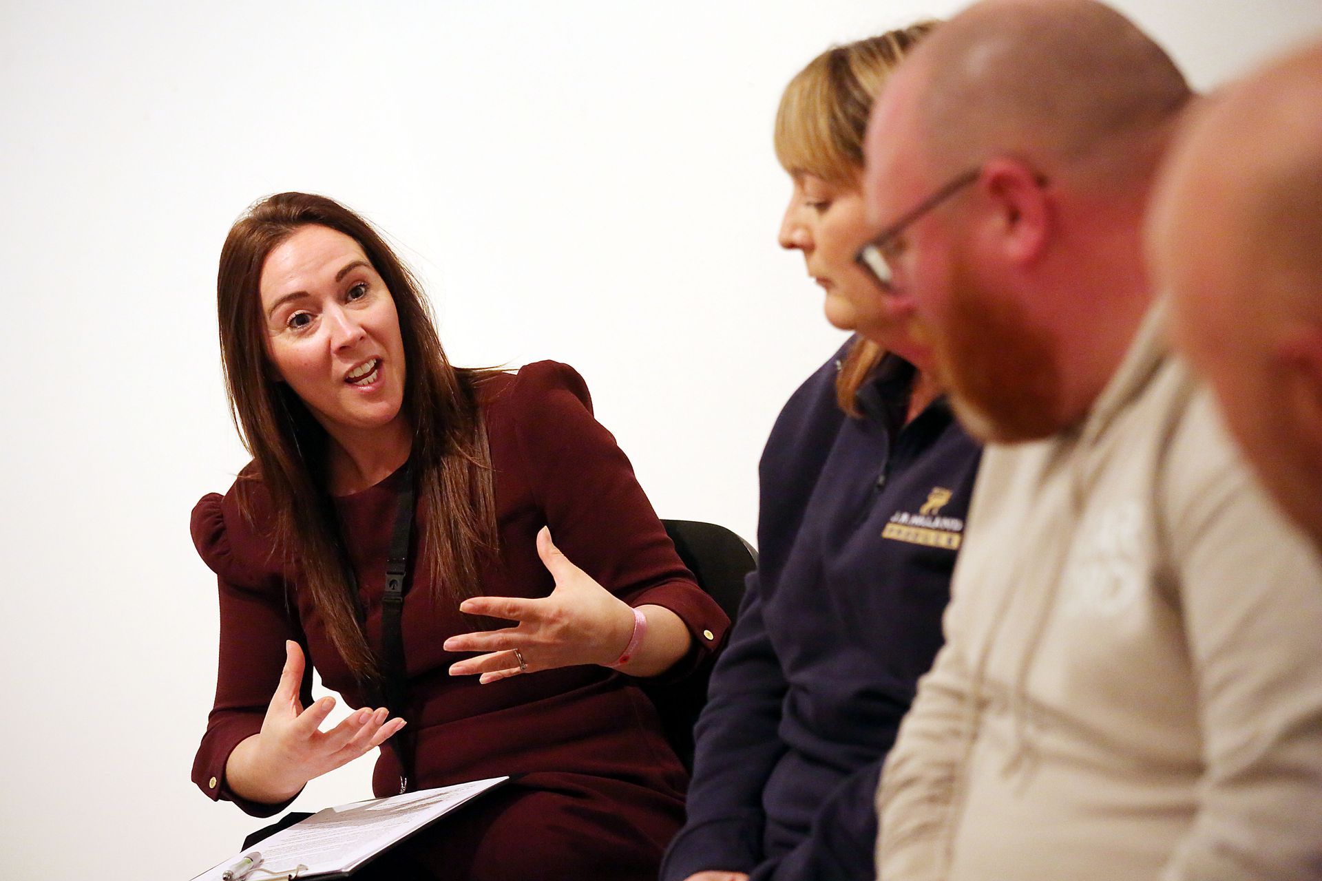 A group of people are sitting in a circle talking to each other.