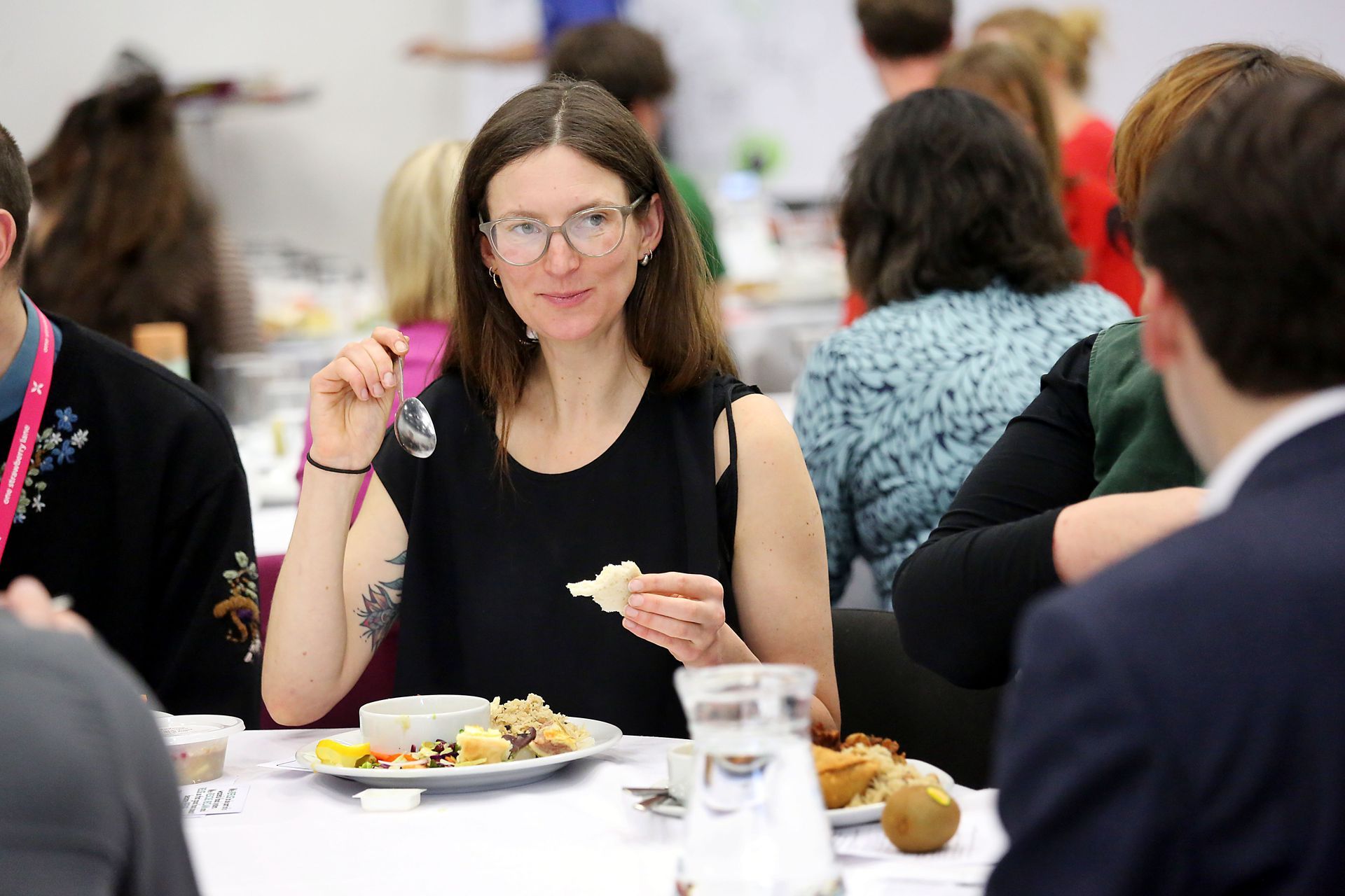 A woman is sitting at a table eating food.