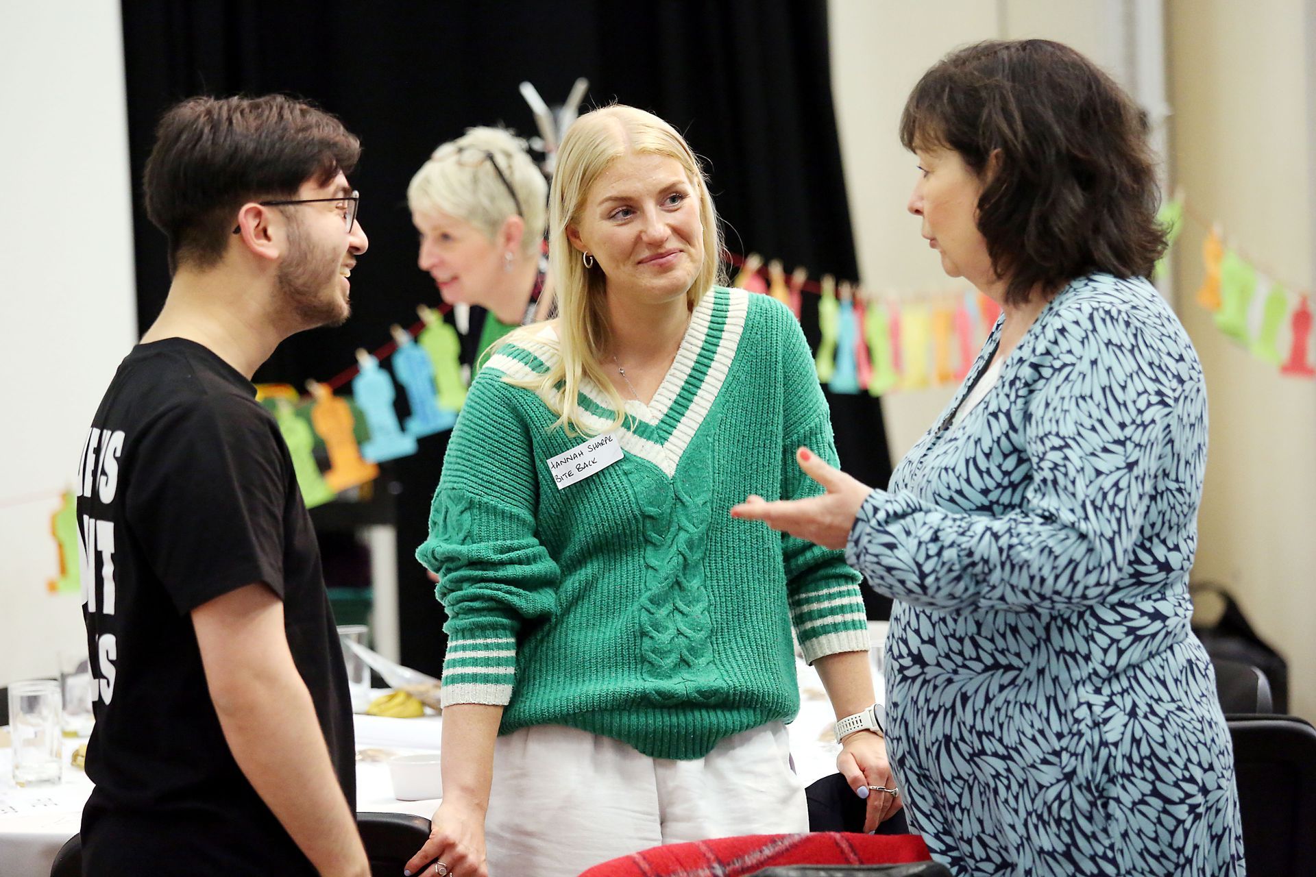 A group of people are talking to each other in a room.
