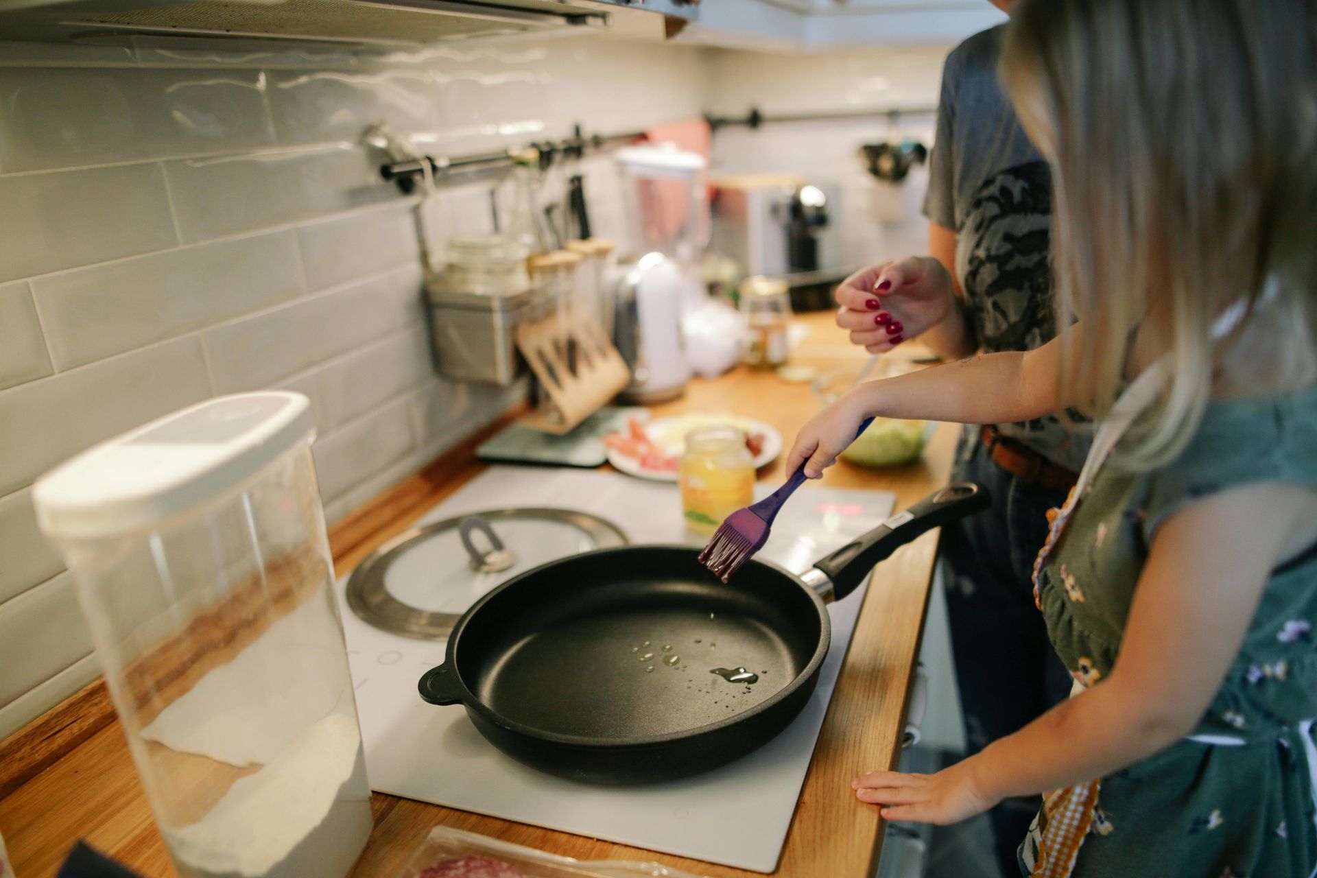 A man and a little girl are cooking food in a kitchen.