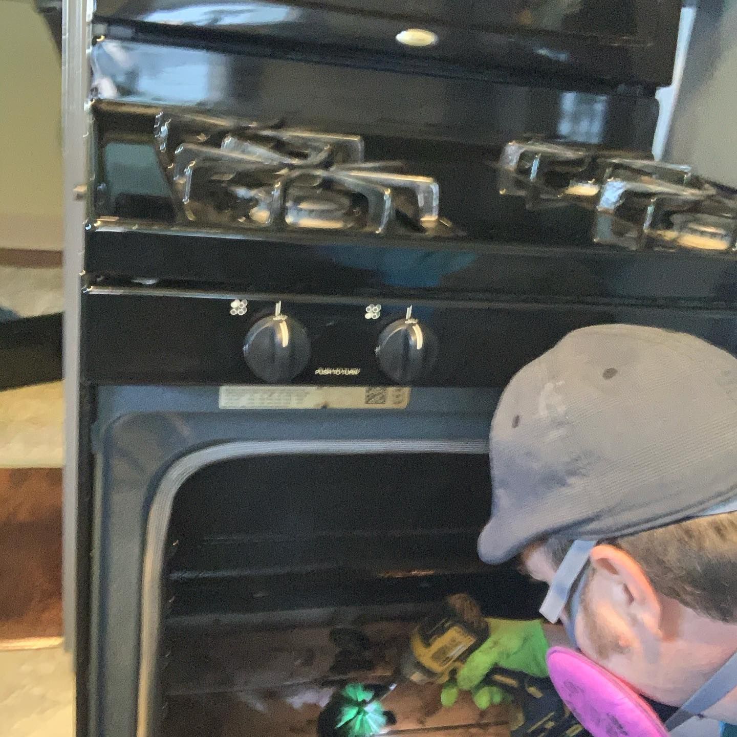 a man wearing a mask is working on a stove