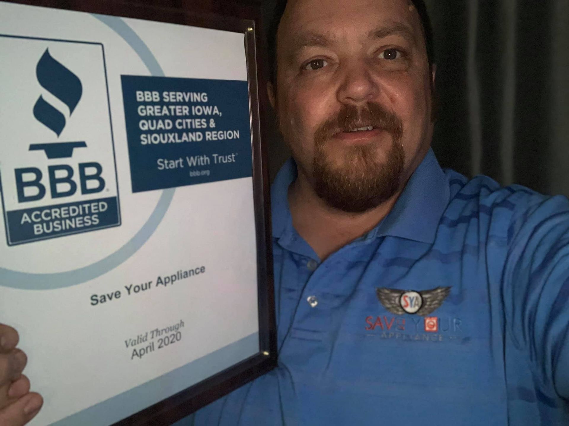 Greg the owner holding their certificate from BBB
