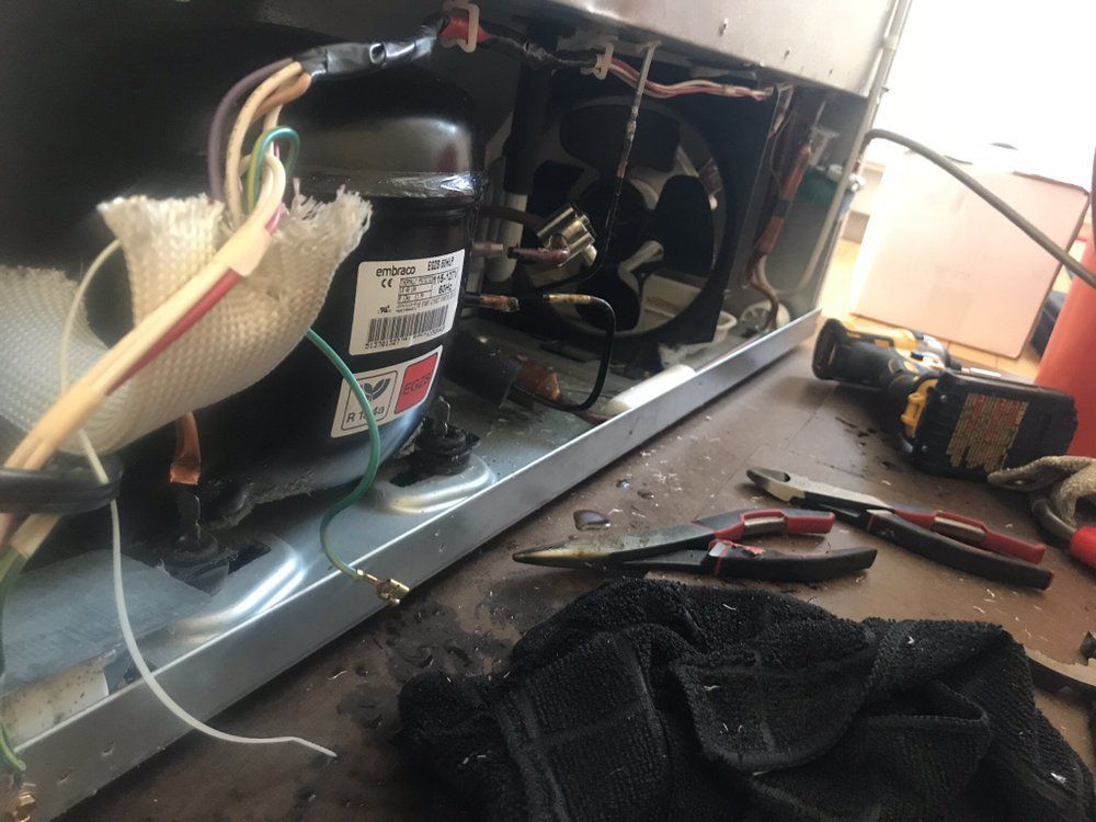 a refrigerator is being repaired on a table with tools .