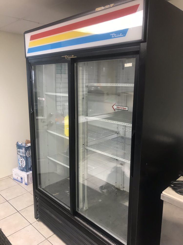 an empty refrigerator with sliding glass doors in a room .