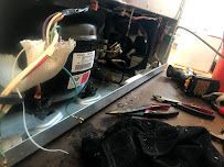 a refrigerator is being repaired on a table with tools .