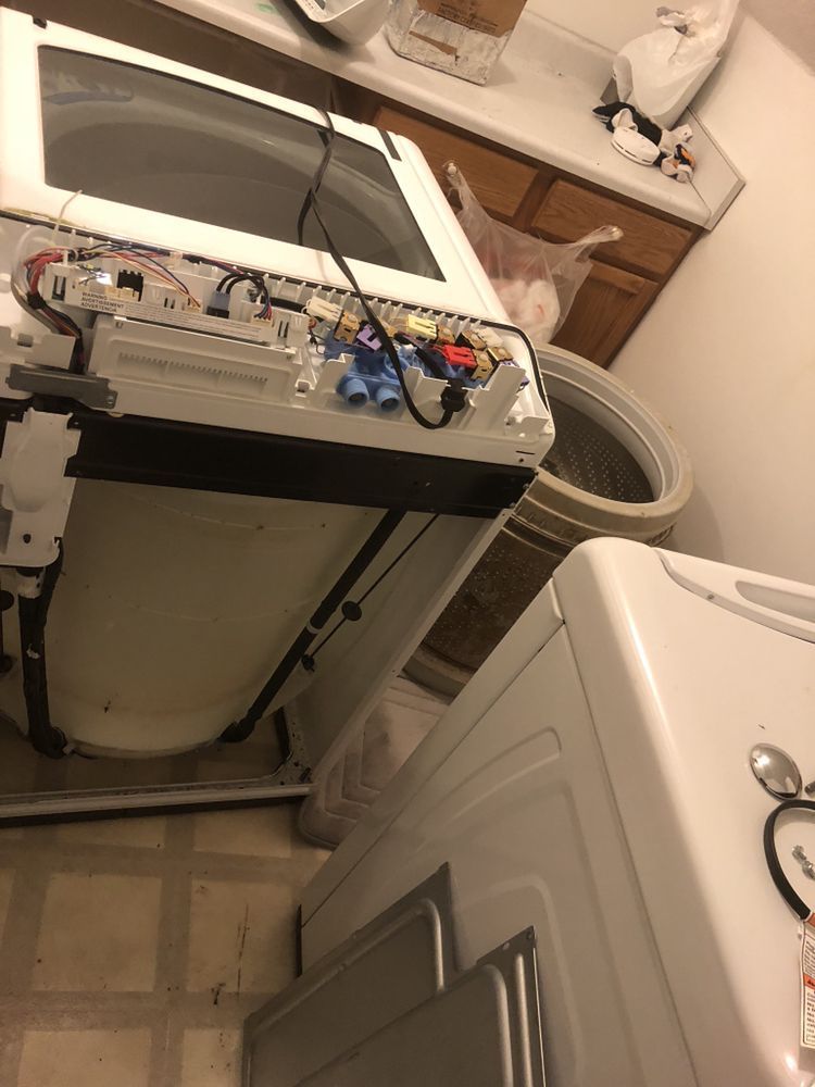 a washer and dryer are sitting next to each other in a laundry room .