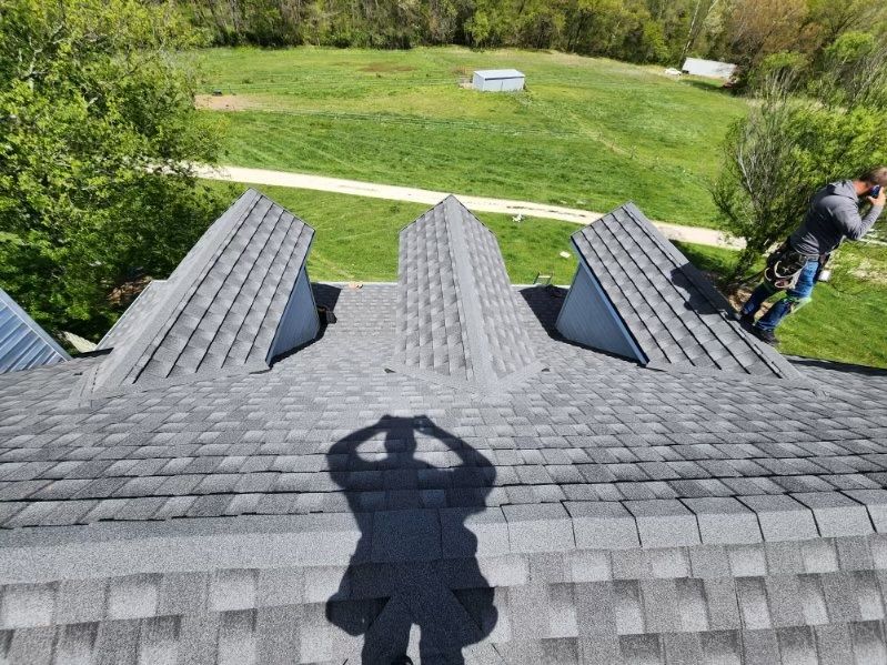 A man is standing on top of a metal roof 