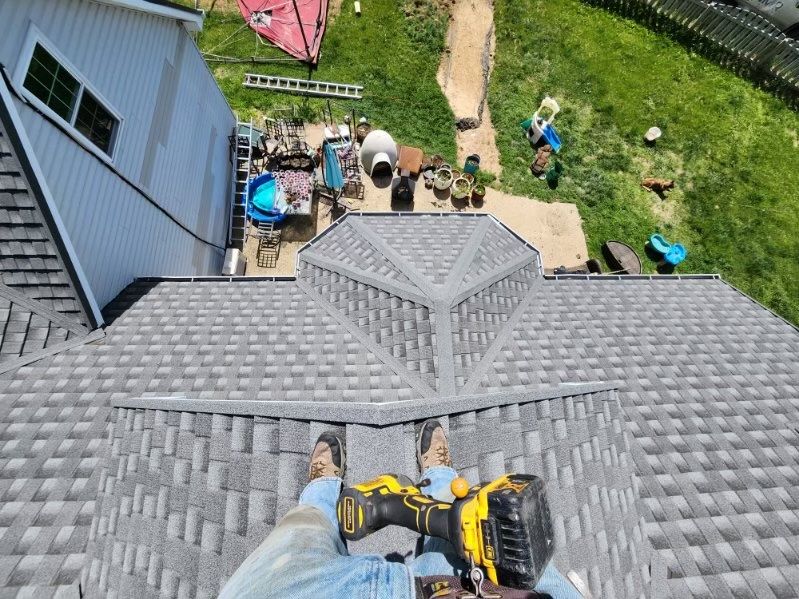 A person is standing on top of a roof 