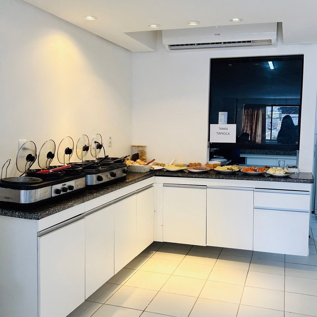 Uma cozinha com armários brancos e um fogão.