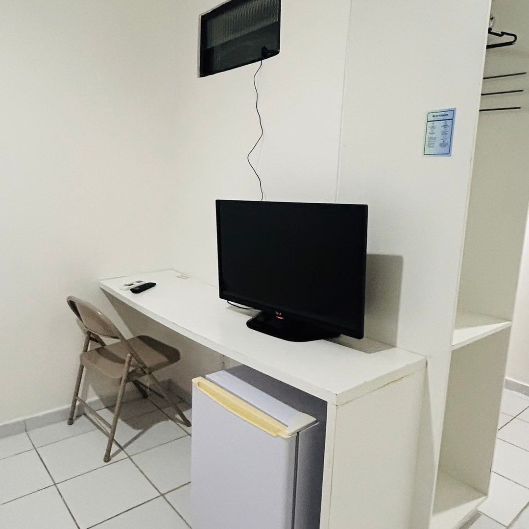 Uma sala com uma escrivaninha, uma cadeira e uma tv