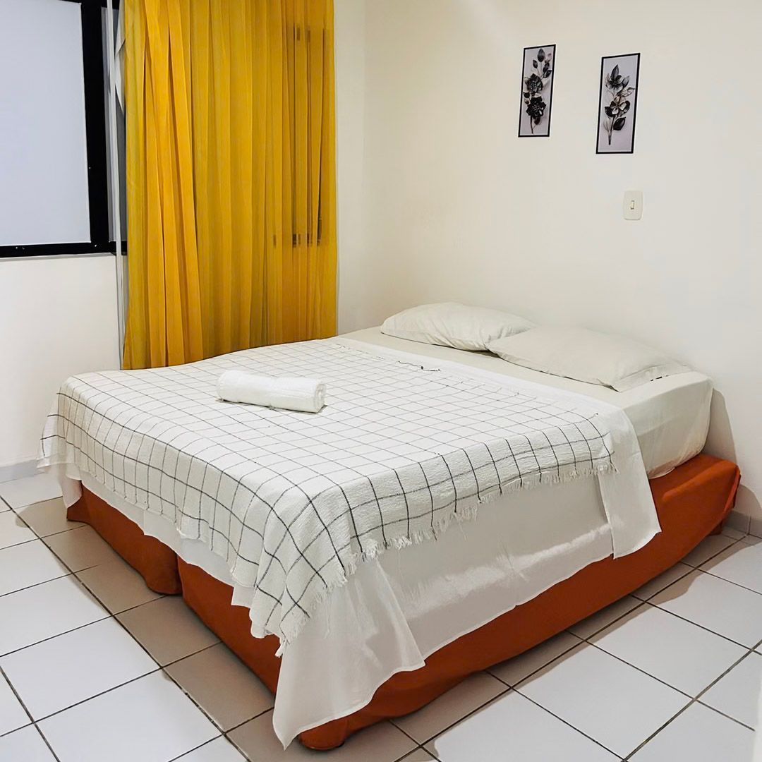 Um quarto com uma cama e cortinas amarelas