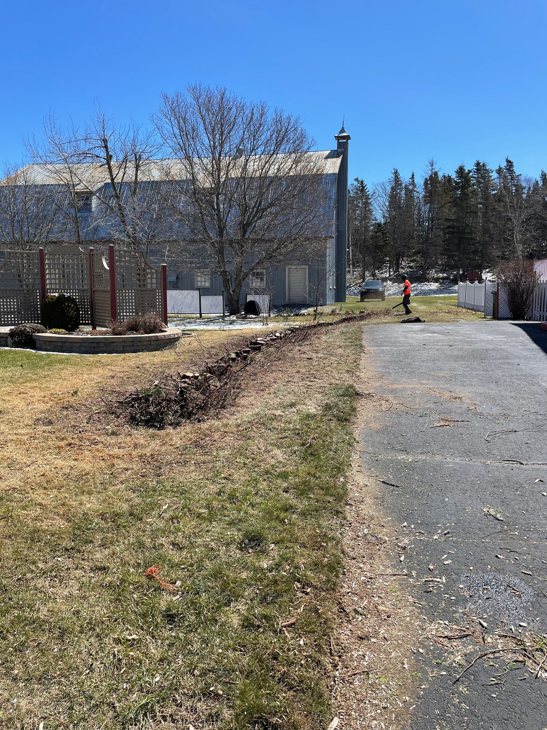 Une personne marche sur un chemin de terre devant une maison.